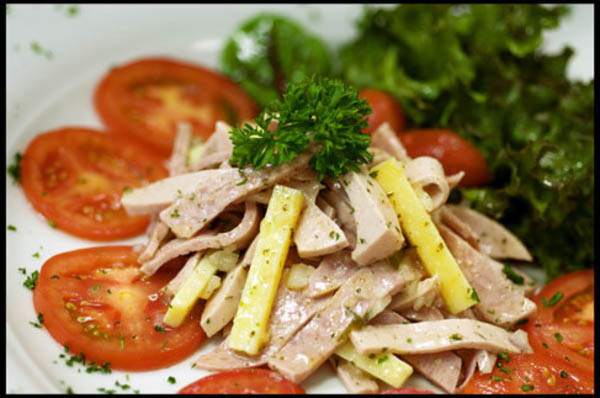 Thinly sliced Bavaria Cold Cut, Swiss Cheese, Pickles and Onions tossed in a White Balsamic Vinaigrette served on a Bed of Greens garnished with Tomatoes A classic German Salad!