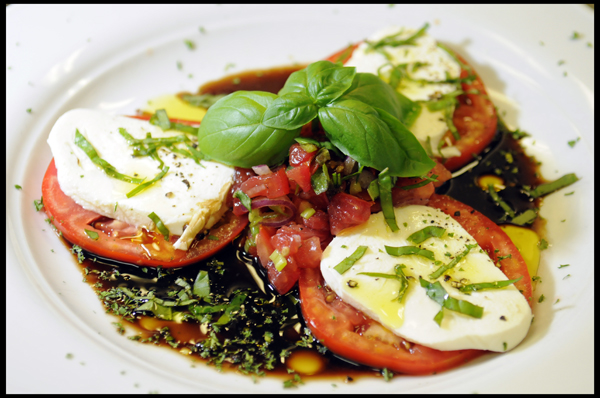 Home-grown tomatoes with fresh mozzarella and basil, drizzled with a balsamic vinaigrette.