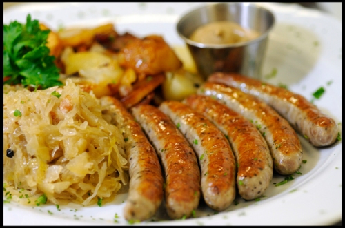 Six Nürnberger Bratwurst with pan-fried potatoes and sauerkraut.