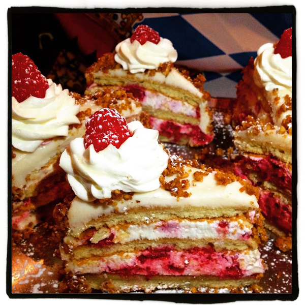 Walnut Raspberry Torte with layers of raspberry whipped cream, light cream cheese icing and oven-roasted walnuts.