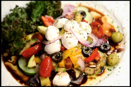 Bell peppers, olives, zucchini, cherry tomatoes, red onions and mozzarella cheese tossed in a balsamic vinaigrette dressing garnished on a bed of greens. 