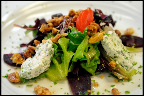 Sliced fresh beet root, herbed goat cheese and toasted walnuts on a bed of salad greens with a Sherry vinaigrette